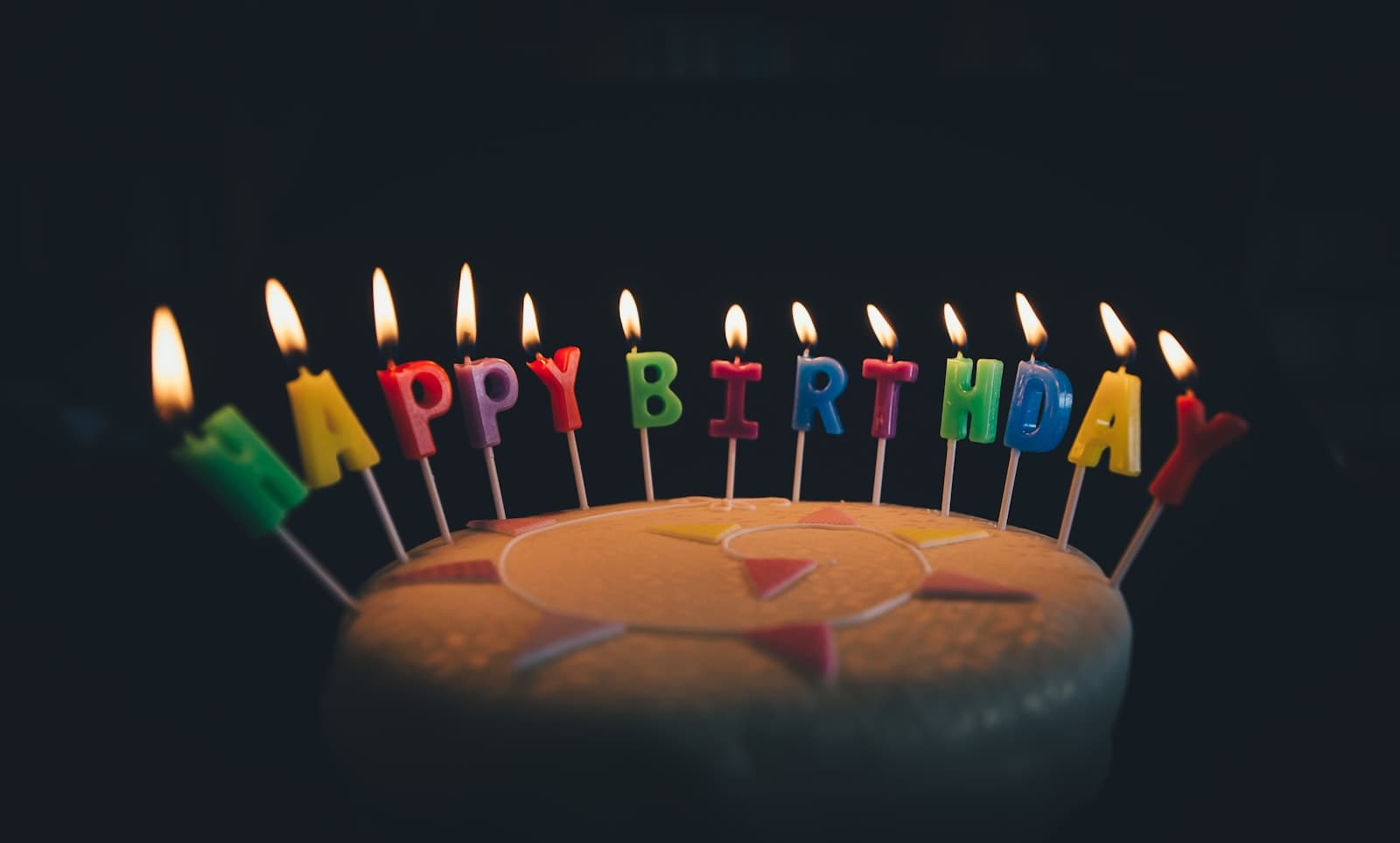 Birthday cake glowing with Happy Birthday candles