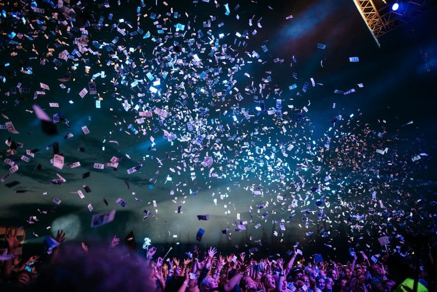 Confetti raining over a cheering evening crowd