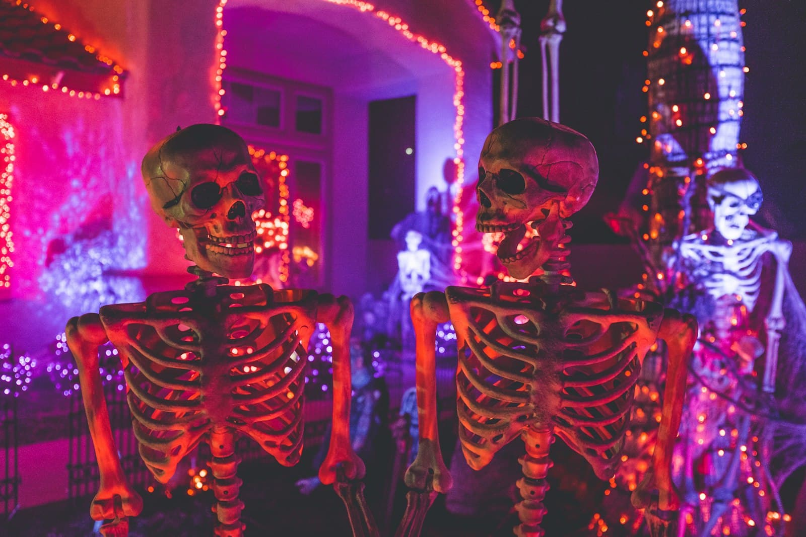 Playful Halloween skeletons under neon party lights
