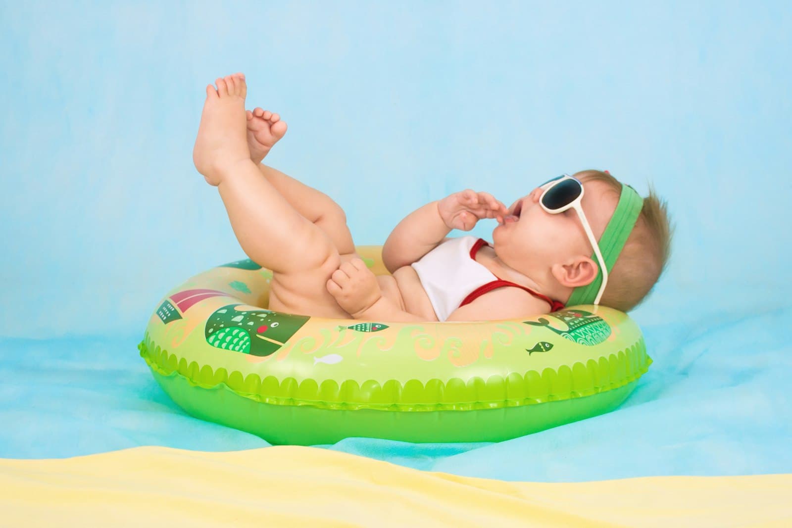 Baby in sunglasses relaxing on a pool float