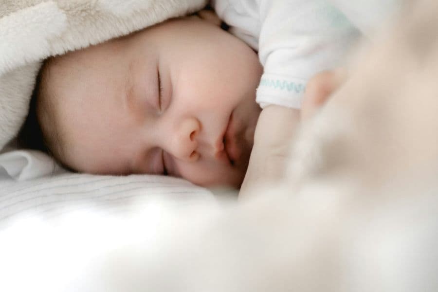 Newborn sleeping peacefully wrapped in soft blankets