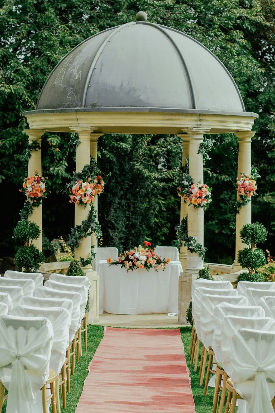 Stone pavilion ceremony dressed in white and blooms