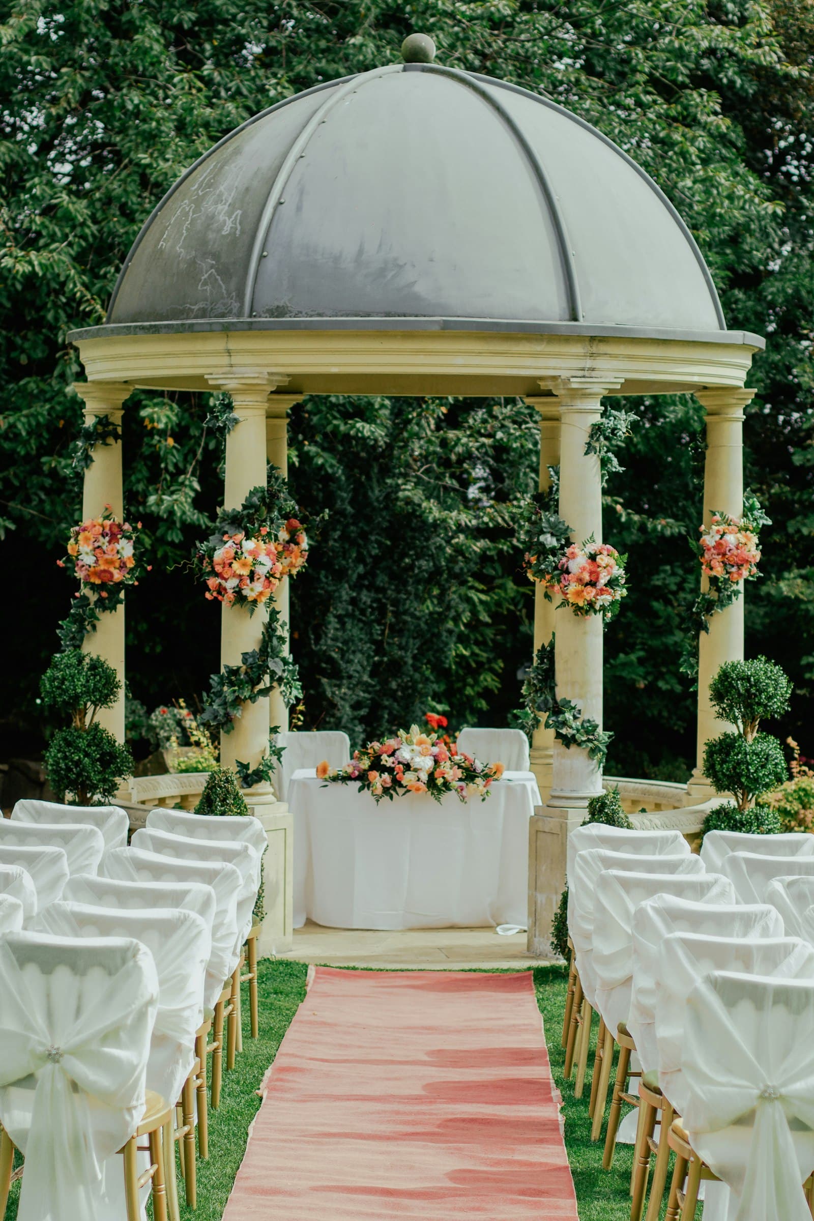 Stone pavilion ceremony dressed in white and blooms